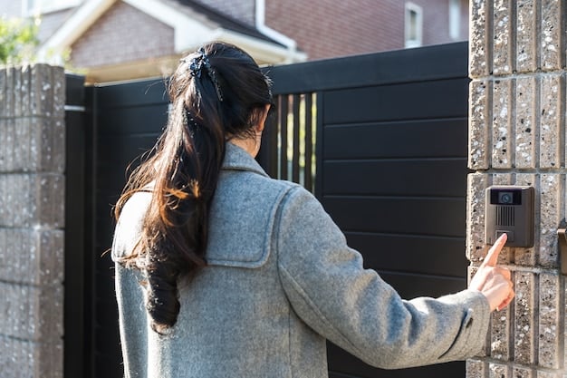 A person installing a wireless security camera on the exterior wall of a house. The camera is weatherproof and has a clear view of the driveway and front yard. The person is using a drill to secure the camera mount.