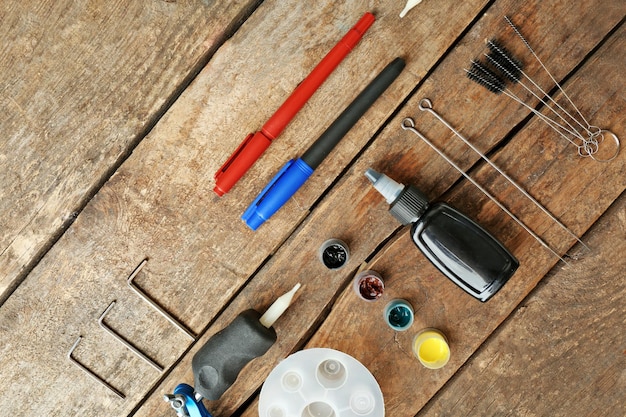 A high-angle shot of various sealing tools and materials arranged on a wooden workbench. Visible items include caulk guns, tubes of caulk (silicone and acrylic), cans of expanding foam, rolls of copper mesh and steel wool, putty knives, and safety glasses.