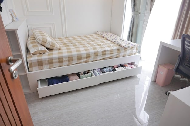 A small apartment bedroom featuring a bed with under-bed storage drawers. The drawers are open, revealing neatly organized bedding and clothing. The bedroom is decorated in neutral tones, with a minimalist aesthetic.