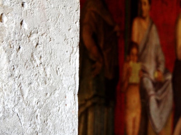 A close-up shot of a textured wall with a combination of rough plaster and smooth paint. The lighting highlights the variations in the surface, creating a sense of depth and visual interest.