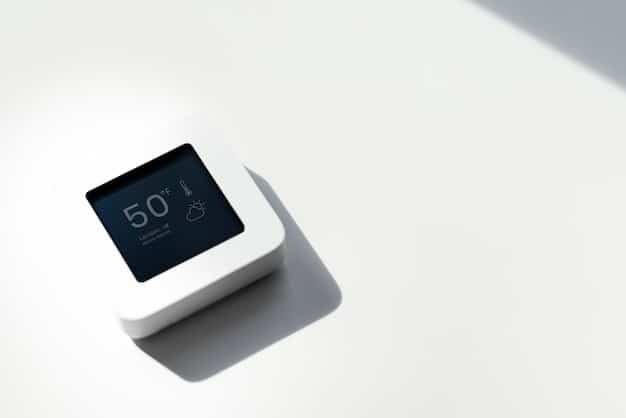 A close-up of a smart thermostat with a minimalist design, displaying the current temperature and energy usage statistics. The thermostat is mounted on a clean, white wall in a modern home setting.