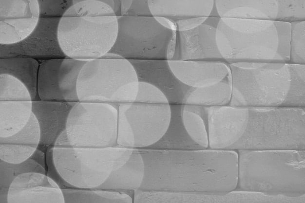 A close-up shot of a textured wall with a geometric pattern created using raised plaster. The lighting highlights the texture and shadows, giving the wall depth and visual interest.