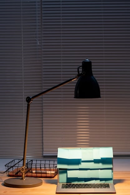 A stylish home office with a desk lamp providing task lighting, a bookshelf with books and decorative objects, and a framed piece of art on the wall highlighted by accent lighting. The room features a neutral color palette with pops of color from the accessories. The scene is well-lit, organized, and inviting, creating a productive and aesthetically pleasing workspace.
