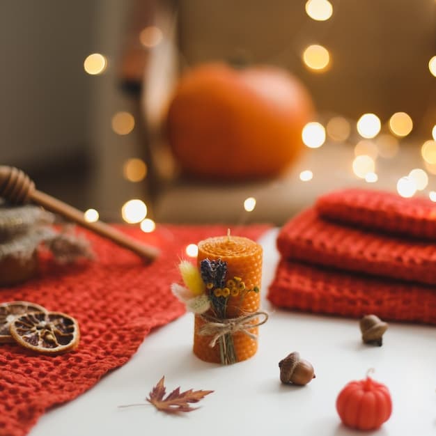 A close-up shot of a coffee table decorated with a scattering of colorful autumn leaves, several small pumpkins, and a lit candle, set against a blurred background of a cozy living room.