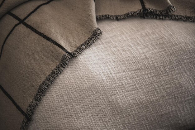 Close-up of various fabric swatches arranged on a table, including velvet, linen, wool, and silk. Soft, diffused lighting highlights the texture and weave of each material.