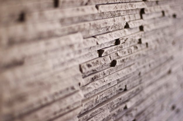A close-up shot of a textured stone wall in a modern living room. The stones have varying sizes and colors, creating a natural and rustic feel. Soft, warm lighting highlights the texture and depth of the stone.
